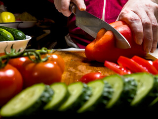 A person is cutting up vegetables on a cutting board