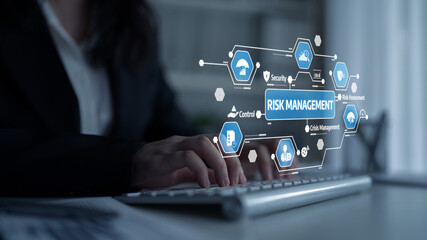 A businesswoman expertly navigates risk management concepts with digital visuals on her computer screen, illustrating modern approaches to security and control in the workplace. Tessel