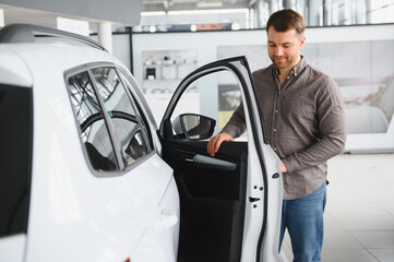 Man exploring options in modern car showroom