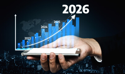 A hand holds a smartphone displaying a futuristic graph that projects business growth trends from 2023 to 2026 against a city background. Tessel