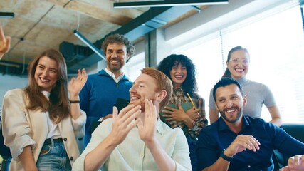 Group of cheerful men and women laughing and clapping in office. Team celebrating success and enjoying good moment together after presentation. Happy colleagues smiling at workplace indoors. - Powered by Adobe