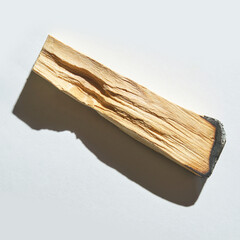 Close-up of single palo santo stick with shadow on white background.