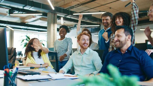 Joyful coworkers raising hands together celebrating success at workplace. Men and women laughing and cheering showing unity and motivation during team spirit moment in collaborative office environment - Powered by Adobe