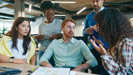 Coworkers debating project results around desk. Man gesturing while explaining graphs on paper as team discusses strategy. Group exchanging ideas and opinions in collaborative office atmosphere. - Powered by Adobe