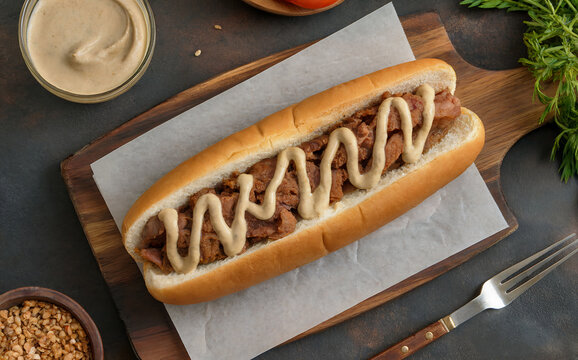 Egyptian cuisine. Kebda. A fresh hot dog-like bun filled with fried liver and topped with tahini.

Top view