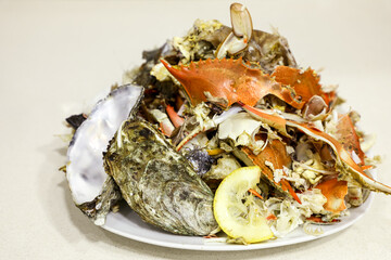 Seafood leftovers piled on a white plate, ready for disposal, illustrating responsible food sorting and sustainable living.
