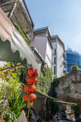 Traditional red Chinese lanterns hanging along a street in an Asian city with buildings and blue sky, concept of cultural celebration, travel and authentic street atmosphere.