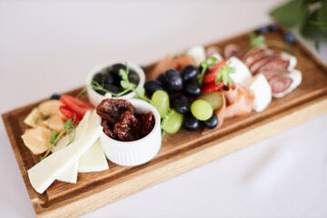 Charcuterie board with cheese, meat and fruits