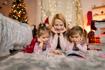 Mother reading a Christmas story to her two daughters