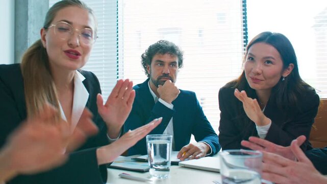 Team having heated discussion during meeting. Female director looking disappointed while colleagues arguing and debating ideas. Tense business situation with disagreement around office table.