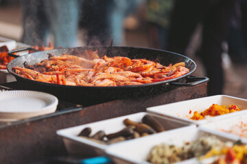 Fresh shrimp sizzling in a large pan at a vibrant outdoor market during a warm afternoon gathering