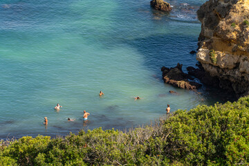 Camilo Beach  (Praia do Camilo) people were sunbathing on the beach and swimming in the ocean....
