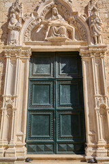 The ornate gothic south entrance of the Franciscan Monastery in the Old Town, featuring the famous Pieta sculpture above the door.