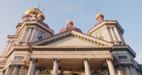 A vintage suitcase left on the steps of a massive door of an antique building with columns. The concept of a journey, waiting, or memories.