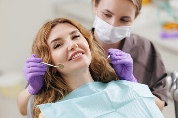 Female adult caucasian patient receiving dental checkup from female dentist