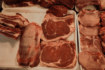 Various cuts of raw beef neatly arranged in a butcher shop display. Fresh red meat background for food and culinary themes