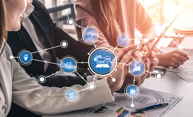 A dynamic scene of business professionals engaged in collaborative work, utilizing digital...