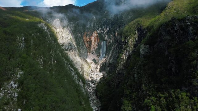Gorgeous aerial view of a massive waterfall on the side of the mountain, 4k