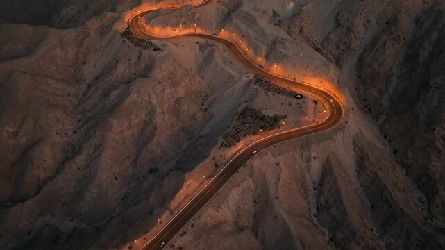 Aerial view of desert mountain roads winding up the Jebel Hafit mountains in Al Ain, Abu Dhabi