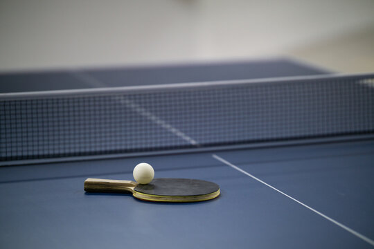 Table tennis racket and ball on table