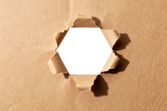 Brown kraft paper texture with a torn hexagonal hole isolated on transparent background, copy space