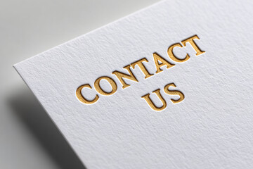 A white card with gold embossed text that reads Contact Us