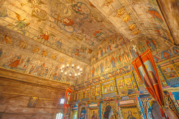 Maramures, Romania - Aug 13, 2025: 18th-century wooden Church of the Archangels Michael and Gabriel in Plopis, Sisesti, Maramures, Romania, with vivid frescoed ceiling and biblical iconography