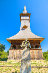 Orthodox wooden church of the Archangels Michael and Gabriel in Plopis, Maramures, Romania, showcasing traditional 18th-century architecture under a clear blue sky