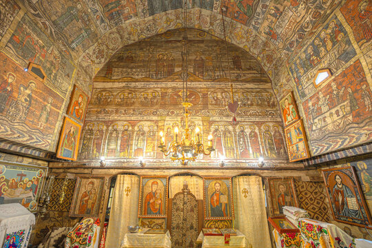 Maramures, Romania - Aug 13, 2025: Wooden interior of the historic Saint Parascheva Church in Maramures, Romania, displaying detailed frescoes and religious icons
