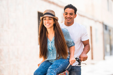 Young mixed-ethnicity couple enjoying time together outdoors during a relaxed day out, walking, laughing and sharing a romantic moment; youthful love, connection, leisure lifestyle and authentic emoti