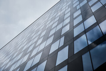 Obraz premium Modern glass office building facade with geometric reflective windows