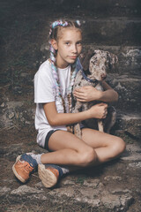 Nice young lady posing on stairs with her lovely leopard dog