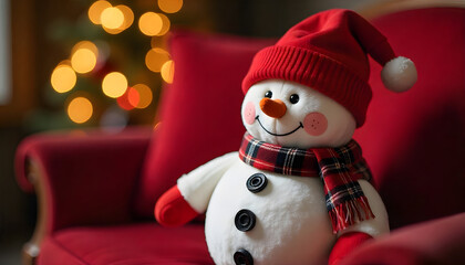 Cute snowman plush toy with a red knitted hat and plaid scarf sitting on a red sofa, surrounded by soft Christmas lights in the background. Cozy festive atmosphere, warm holiday decor, and cheerful