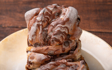 Sweet bread with chocolate, a delicious sweet bread with chocolate placed on a plate on rustic wood, selective focus.