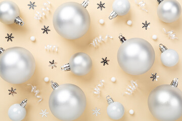 Grey Christmas balls with decor on color background, top view