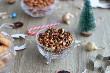 Various Christmas decorations, cookies, chocolate and nuts on wooden background. Selective focus.