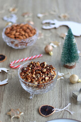 Various Christmas decorations, cookies, chocolate and nuts on wooden background. Selective focus.