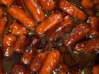 Small cocktail franks smothered in barbecue sauce.