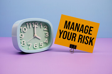 Manage Your Risk text and alarm clock on blue and purple background