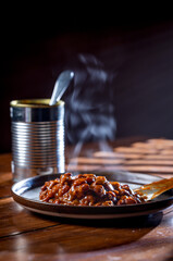 A can of chilly and a plate with chilly beans on it ready to be devoured