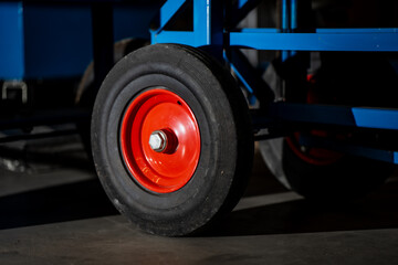 Fototapeta premium Industrial transport wheel showing red metal hub and rubber tire representing warehouse mobility, logistics tools, material handling and manufacturing equipment