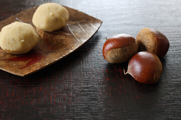 漆塗り板に置かれた皿にのせた栗きんとん