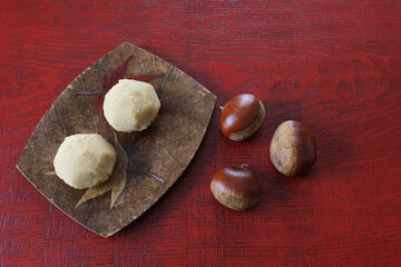 漆塗り板に置かれた皿にのせた栗きんとん