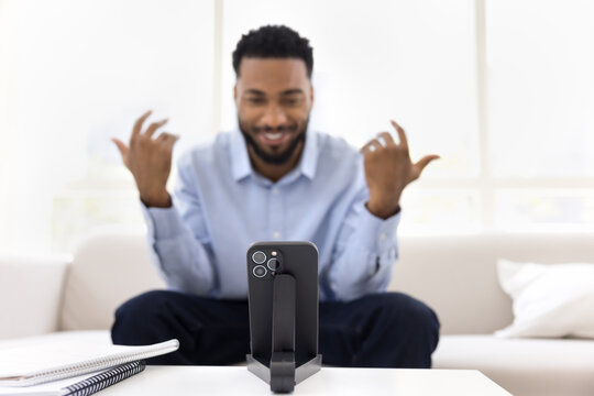 Closeup focus on smartphone placed on stand in front man - Powered by Adobe