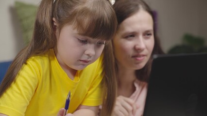 girl school student teaches lessons with mother. mother daughter are working test digital laptop.active teamwork. school life little student. home school tutor. child kid training indoors together.