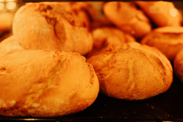 Golden brown bread rolls just baked, glowing with warmth and texture. Perfect background for bakery, food, and culinary themes