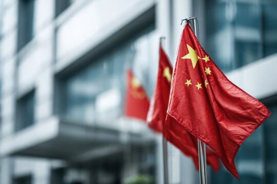 A cluster of Chinese national flags fluttering against the backdrop of a modern office building, reflecting China's global presence and economic influence in the world. - Powered by Adobe