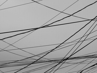 many black power cables crossing the sky in different directions