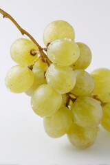 Un grappolo di uva bianca, con acini freschi e maturi. Sfondo bianco.