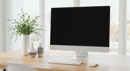 Computer on desk with vase of flowers in bright modern indoor setting.
